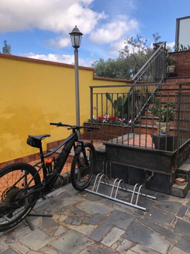 una bicicletta parcheggiata accanto a un edificio con un lampione di OPUNTIA DELL'ETNA BIKE HOUSE a Mascalucia