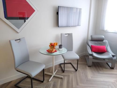 une salle à manger avec une table et deux chaises dans l'établissement Studio Cannes Grand Hôtel Eider, à Cannes