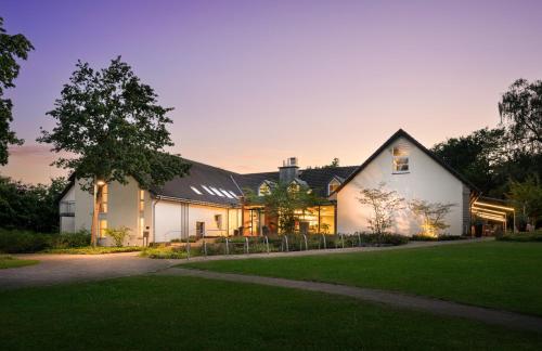 a white house with a black roof at Flussbett Hotel in Gütersloh