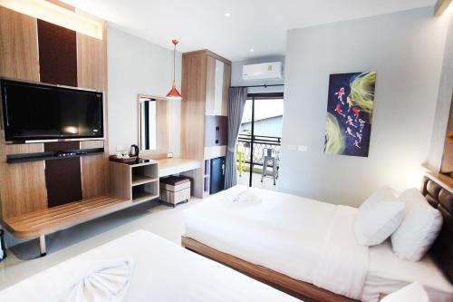 a hotel room with a bed and a flat screen tv at Avarin Resort in Pak Chong