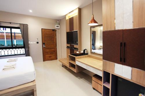 a hotel room with a bed and a television at Avarin Resort in Pak Chong