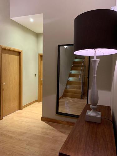 a lamp on a table in a room with a mirror at Quebecs Luxury Aparthotel in Leeds