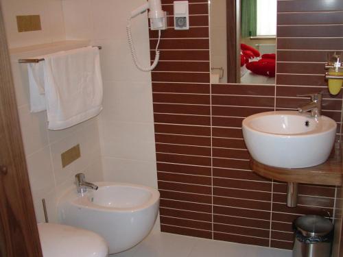 a bathroom with a sink and a toilet and a mirror at Hotel Szarlota - Kompleksowo na Kaszubach in Kościerzyna