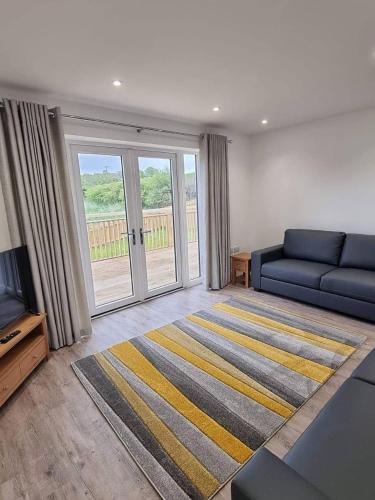 a living room with a blue couch and a tv at Copper Cottage in Rothbury