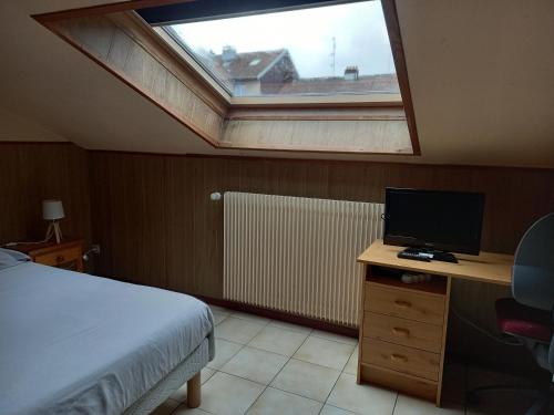 une chambre avec un lit et un bureau avec un ordinateur dans l'établissement Les appartements du Lion de Belfort, à Belfort