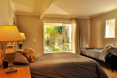 een slaapkamer met 2 bedden en een groot raam bij Glentana Beach Rental in Groot Brak Rivier