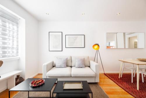 a living room with a white couch and a table at Navegantes Townhouse by Olala Homes in Cascais