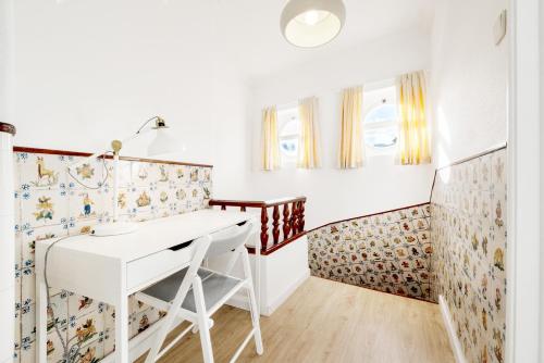 a home office with a white desk and wallpaper at Navegantes Townhouse by Olala Homes in Cascais