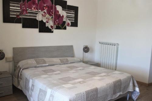 a bedroom with a bed and flowers on the wall at Fattoria Cristina Bilo Rosa in Castelnuovo Magra