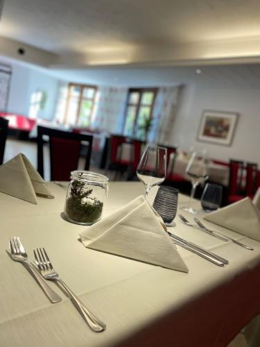 アルテンシュタットにあるHotel & Restaurant Fischerの白いテーブルクロスと銀器が置かれたテーブル