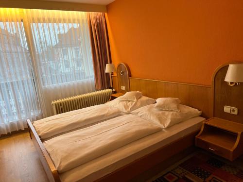a bed in a room with a large window at Hotel Schwan in Hügelsheim