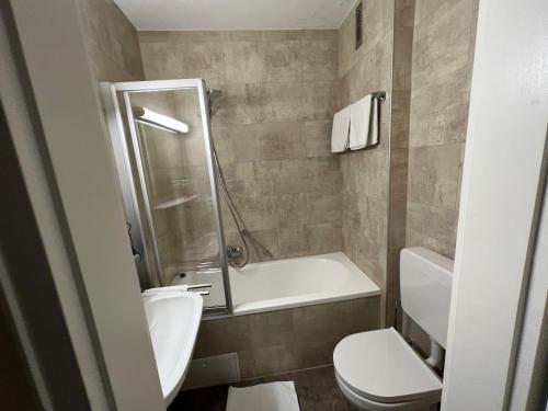 a bathroom with a toilet and a sink and a shower at Hotel Schwan in Hügelsheim