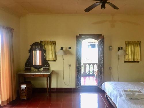 a bedroom with a bed and a door with a window at Puri Mandala Kaleran in Ubud