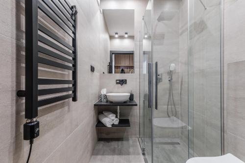 uma casa de banho com uma cabina de duche em vidro e um lavatório. em Smrekowa Ostoja em Poronin