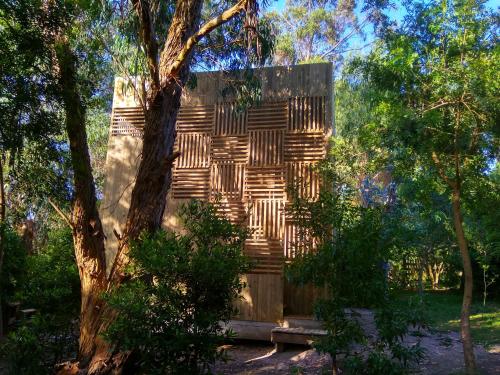 a wooden building in the middle of some trees at Posada IRSIS in La Pedrera