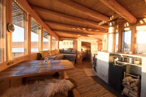 ein großes Wohnzimmer mit einem Tisch in einer Hütte in der Unterkunft Hillagammi, the unique beauty in the Wilderness in Utsjoki