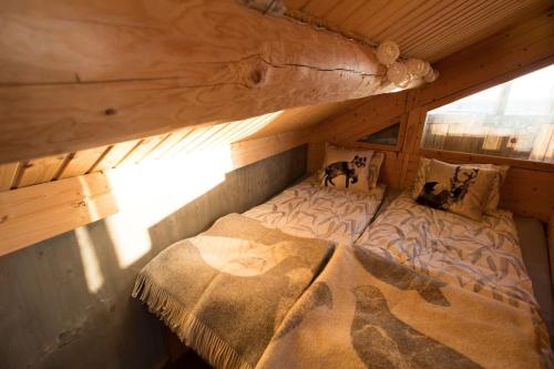 ein großes Bett in einer Holzhütte mit in der Unterkunft Hillagammi, the unique beauty in the Wilderness in Utsjoki