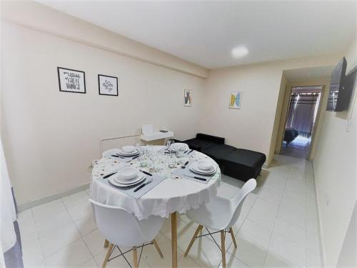 a dining room with a white table and white chairs at Balcarce 146 in San Miguel de Tucumán