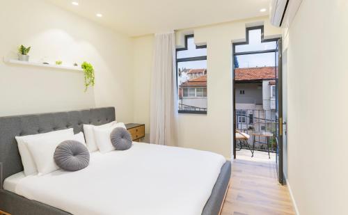 a bedroom with a bed and a large window at The Pearl of Nachlaot Apartments in Jerusalem