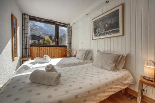 une chambre avec deux lits et une grande fenêtre dans l'établissement Apartment Scott, à Chamonix-Mont-Blanc