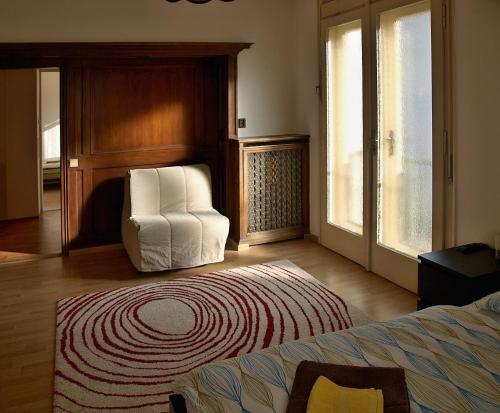 a bedroom with a white chair and a bed at Apartments Tronicek in Prague