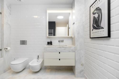 ein weißes Bad mit einem WC und einem Waschbecken in der Unterkunft WHome Prime Location Contemporary Luxury Apartment w/ AC & Elevator in Lissabon