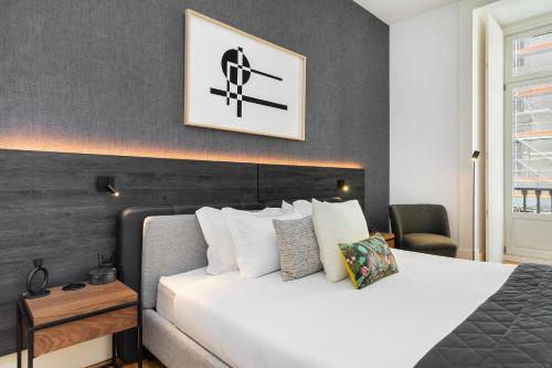 ein Schlafzimmer mit einem großen Bett mit einer weißen Tagesdecke in der Unterkunft WHome Prime Location Contemporary Luxury Apartment w/ AC & Elevator in Lissabon