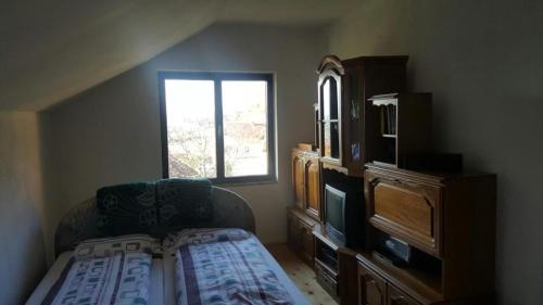 sypialnia z łóżkiem, komodą i oknem w obiekcie Guest house Una w mieście Bihać