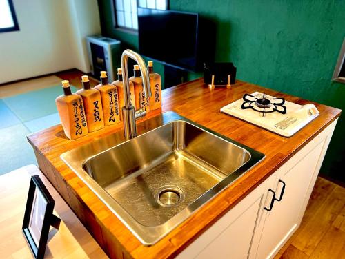 a kitchen with a sink and a wooden counter top at Swiss Inn in Sapporo