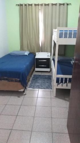 a bedroom with two beds and a dresser and a bunk bed at Residencial Gil in Palhoça