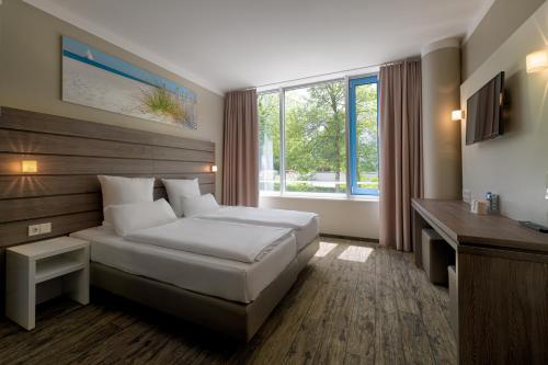 a hotel room with a bed and a window at Tulip Inn München Messe in Munich