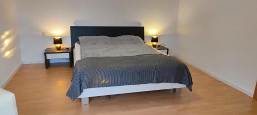 ein Schlafzimmer mit einem Bett mit zwei Lampen an zwei Tischen in der Unterkunft FeWo Lindlar, Monteurwohnung in Lindlar