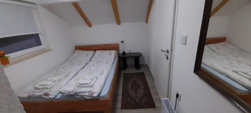 a small bedroom with two beds and a mirror at Ravne weekend house in Visoko