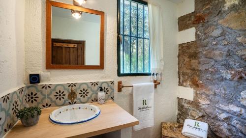 un bagno con lavandino e specchio di Cortijo La Alberquilla Íllora by Ruralidays a Illora