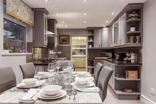 comedor con mesa y sillas en la cocina en 4 bedroom house, 2 Min Walk From Station, en Londres