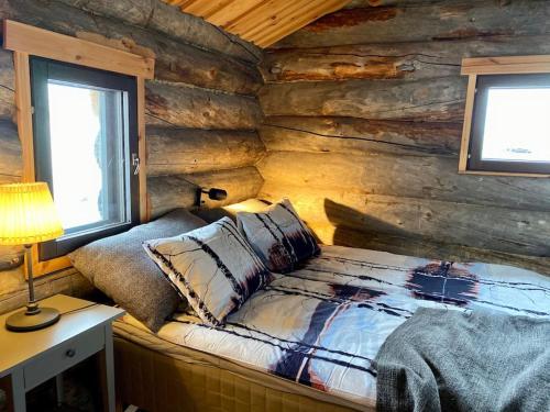 um quarto com uma cama num chalé de madeira em Tunturikelo - beautiful log cottage in the Fells em Utsjoki