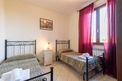 una camera da letto con due letti e una finestra di Papà Giuseppe La Terrazza a Cortona