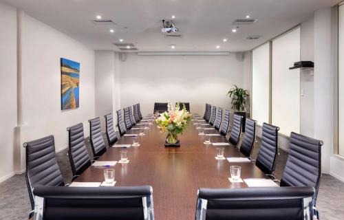 a conference room with a long table with chairs and flowers at Arawa Park Hotel, Independent Collection by EVT in Rotorua