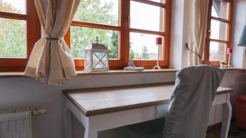 a desk in a room with windows and a lamp at Landhaus Charlotte - Storchennest in Wassersuppe