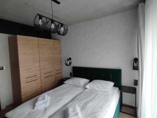 a bedroom with a bed with a green headboard at Apartament 413 Biała Perła in Stronie Śląskie