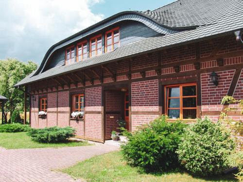 a brick house with a black roof and windows at Landhaus Charlotte - Feldblick in Wassersuppe