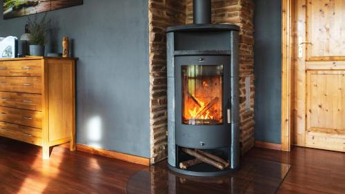 a wood stove in a room with a wall at Landhaus Charlotte - Feldblick in Wassersuppe