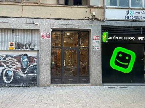 a store front with a green sign on the doors at Apartamento Mani en Avenida España con terraza in Albacete