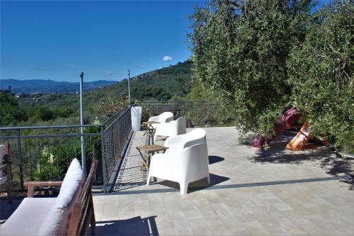 a balcony with white chairs and a view of the hills at Fattoria Cristina - Bilo Verde in Castelnuovo Magra
