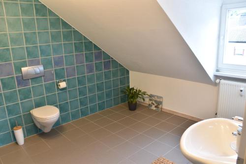 a bathroom with a toilet and a sink at Ferienwohnung Happynest in Birresborn