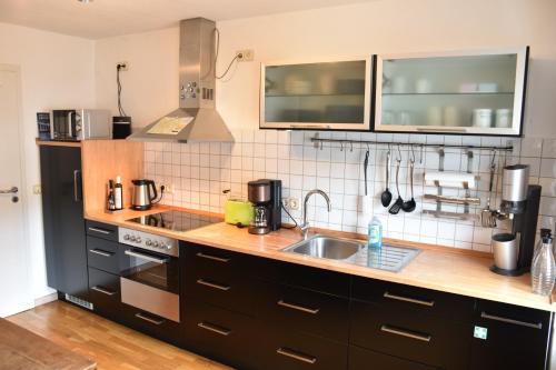 a kitchen with a sink and a stove top oven at Ferienwohnung Happynest in Birresborn