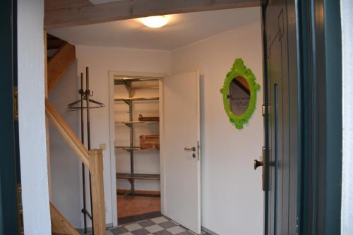 a hallway with a white door and a green mirror at Ferienwohnung Happynest in Birresborn