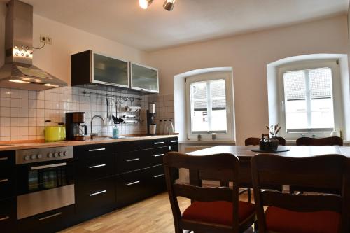 - une cuisine avec une table, des chaises et une cuisinière dans l'établissement Ferienwohnung Happynest, à Birresborn