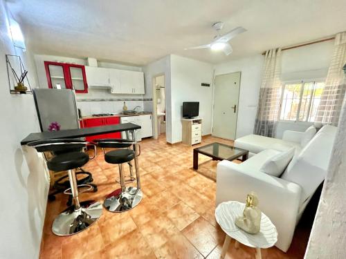a living room with a couch and a table at Estudio adosado acogedor con jardín, barbacoa y parking privado in Alicante