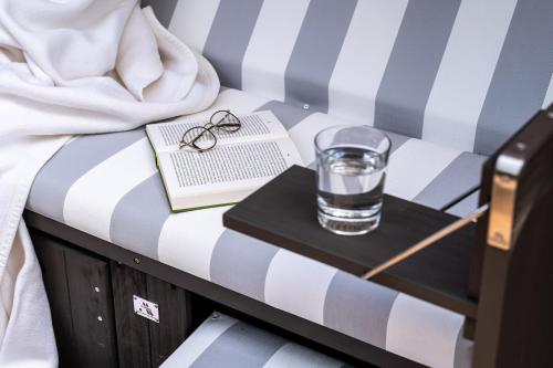 a glass of water and a book on a table at Strandhafer Aparthotel in Warnemünde